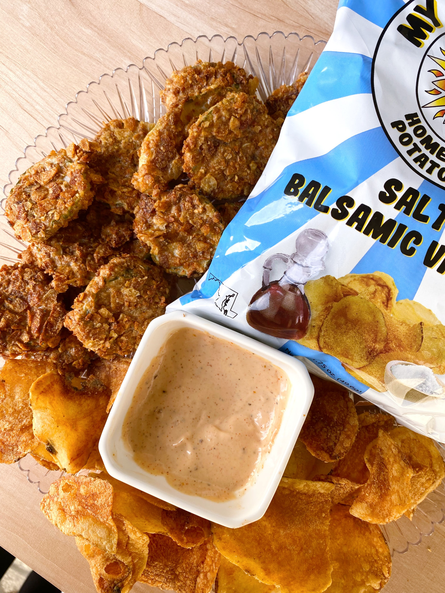Basket of chip crusted fried pickle chips with dipping sauce